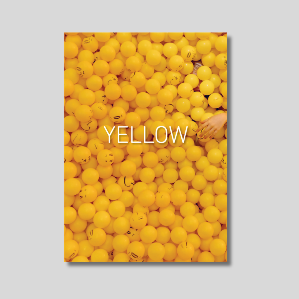 YELLOW photobook cover showing ball pit of yellow plastic balls and hand reaching into the pit