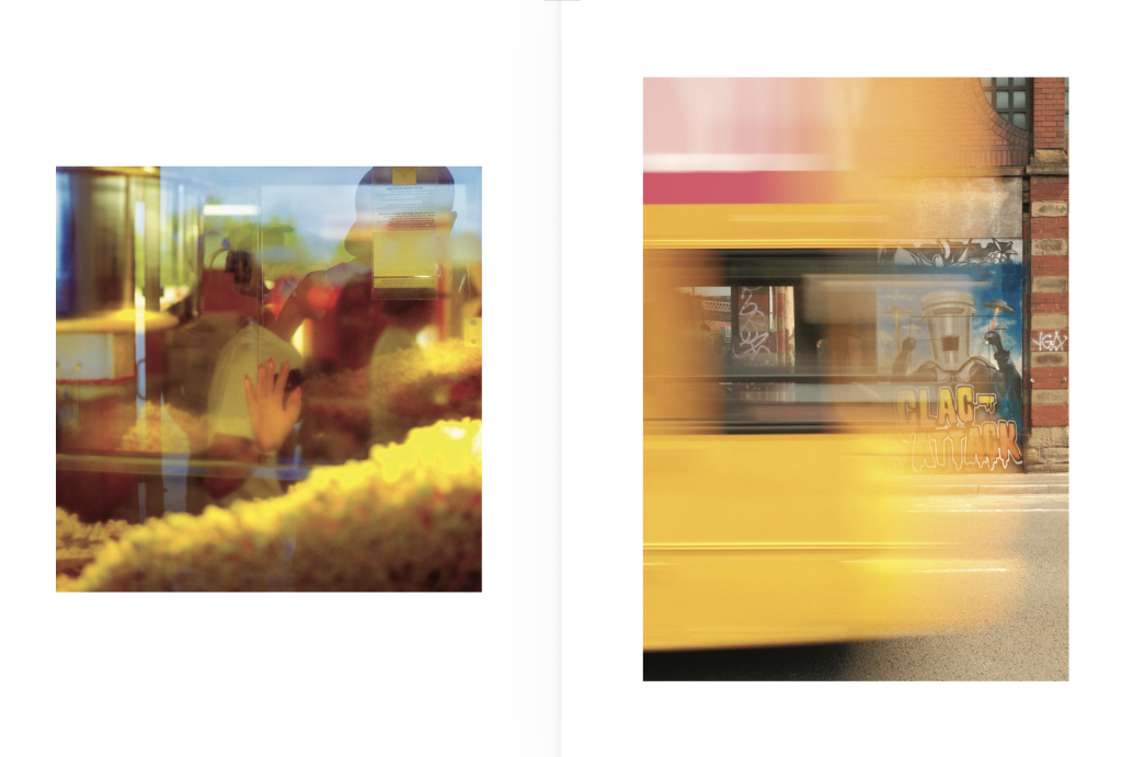Photobook page spread with two photos on white pages: a blurred shot through a window, and a blurred yellow bus in motion